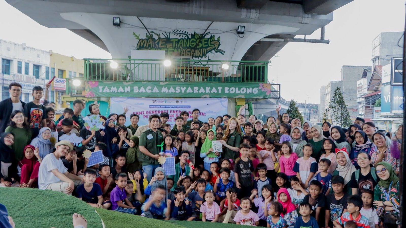 (Foto bersama relawan GEN-B bersama anak – anak TBM Kolong dan masyarakat dalam kegiatan menyampaikan dongeng dengan tema “Kami Generasi Energi Bersih: Petualangan Bersama Kurangi Emisi” dan games seputar energi bersih)